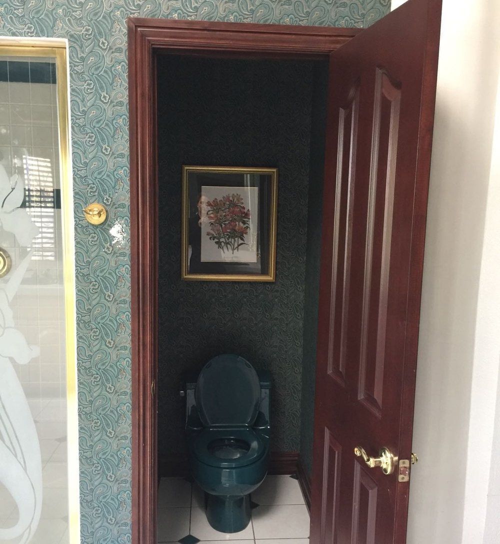 A bathroom with a toilet and a picture on the wall