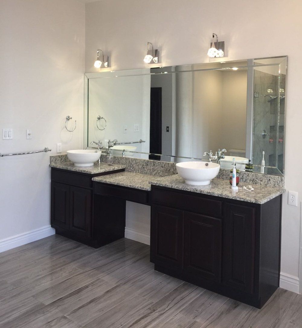 A bathroom with two sinks and a large mirror.