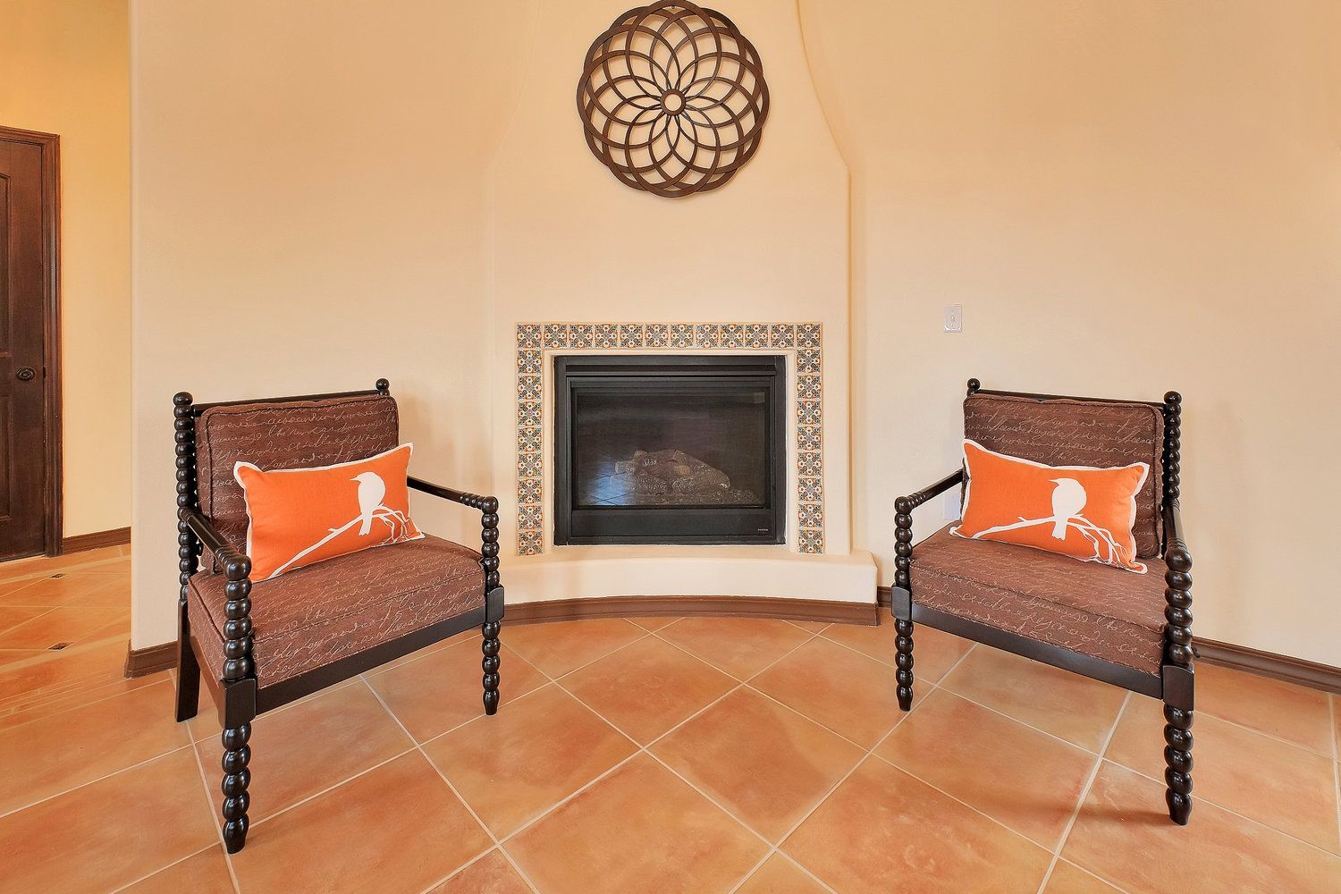 Two chairs are sitting in front of a fireplace in a living room.