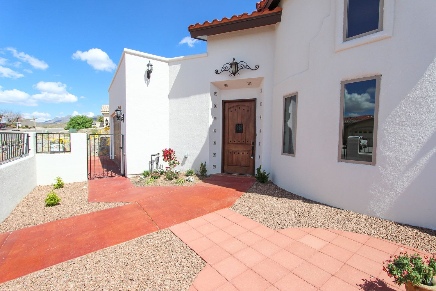A white house with a red walkway leading to the front door