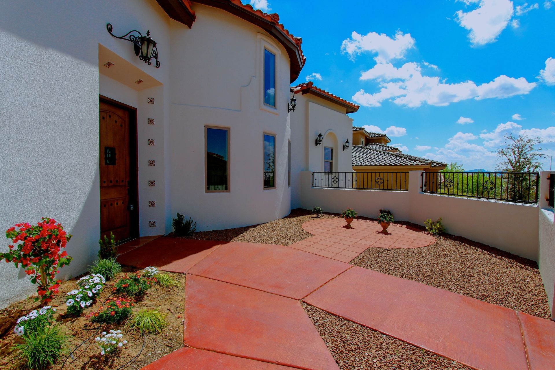 A white house with a red driveway in front of it