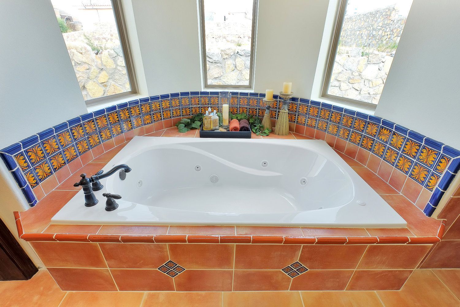 A bathroom with a jacuzzi tub surrounded by tiles