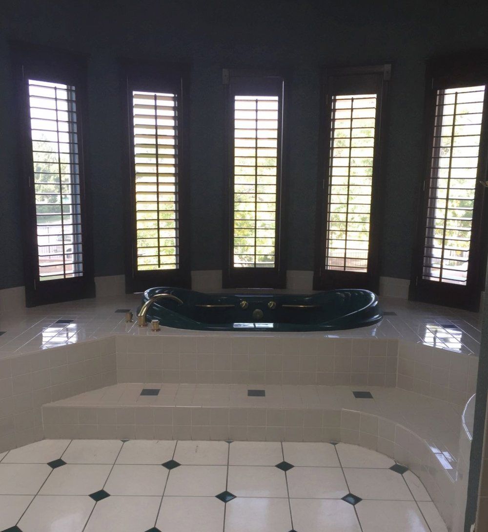 A bathroom with a jacuzzi tub surrounded by windows