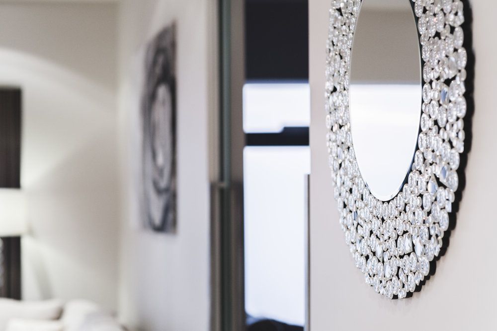 A large mirror is hanging on a wall in a living room.