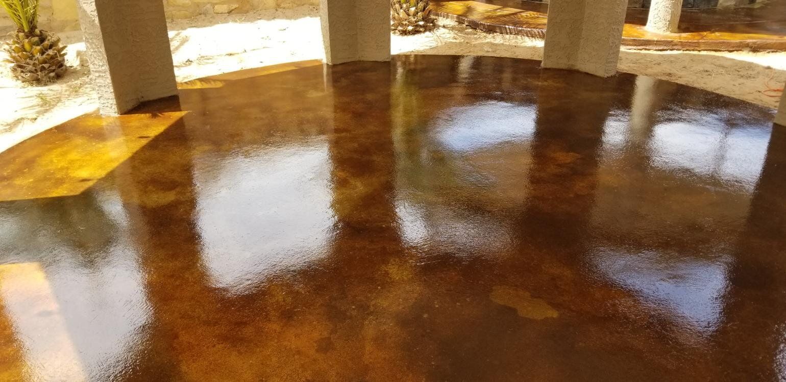 A shiny concrete floor in a room with columns.