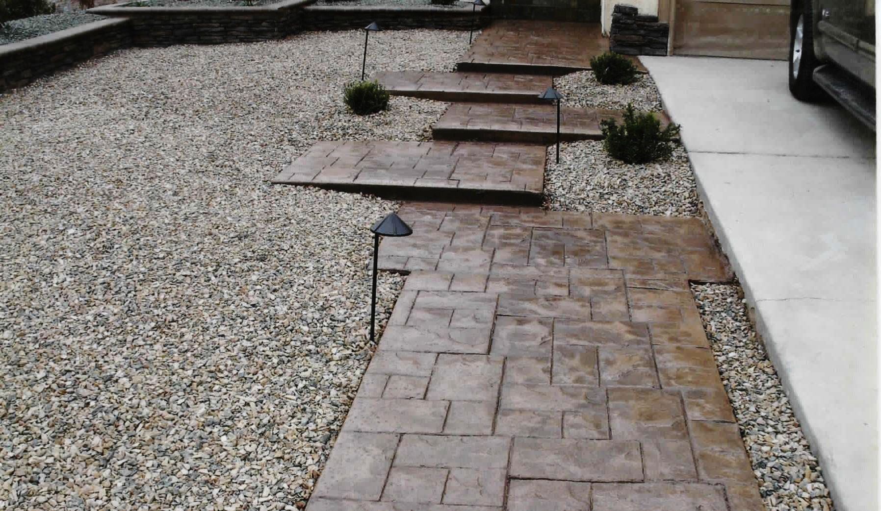 A concrete walkway with steps leading up to a house