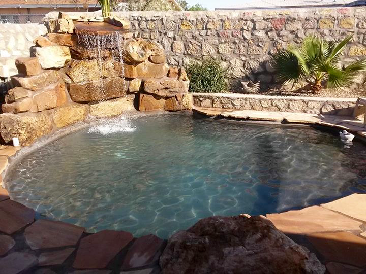 A large swimming pool with a waterfall in the background