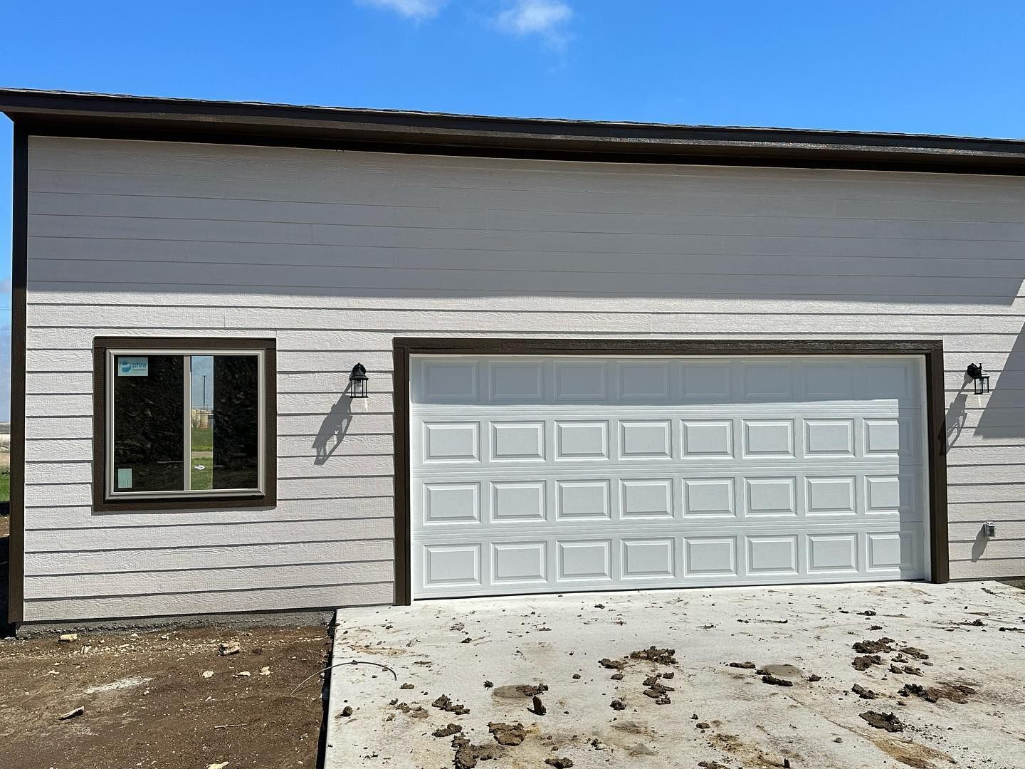 A white garage door is sitting in front of a house.