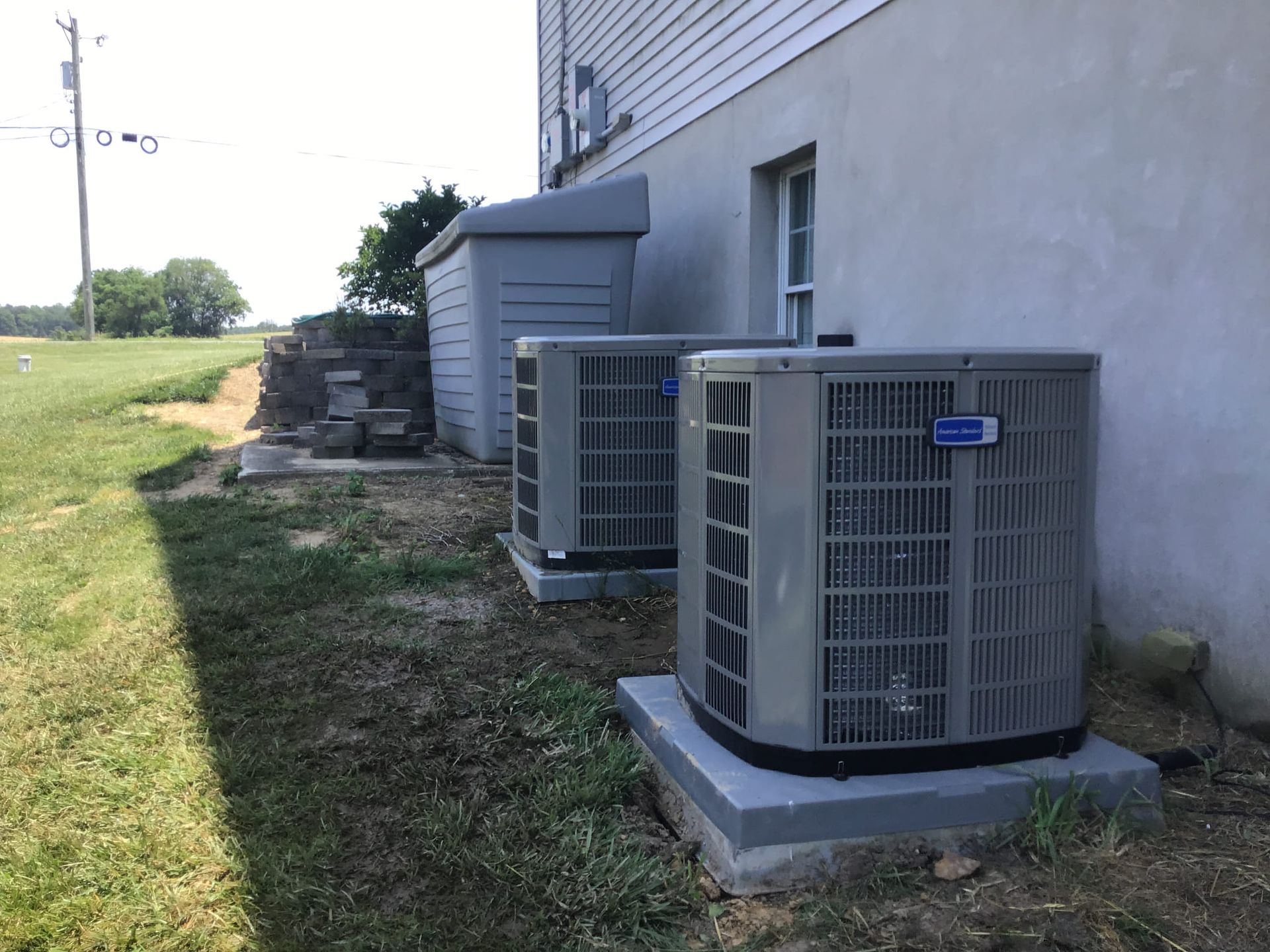 A white air conditioner is sitting on a tiled floor next to a window.