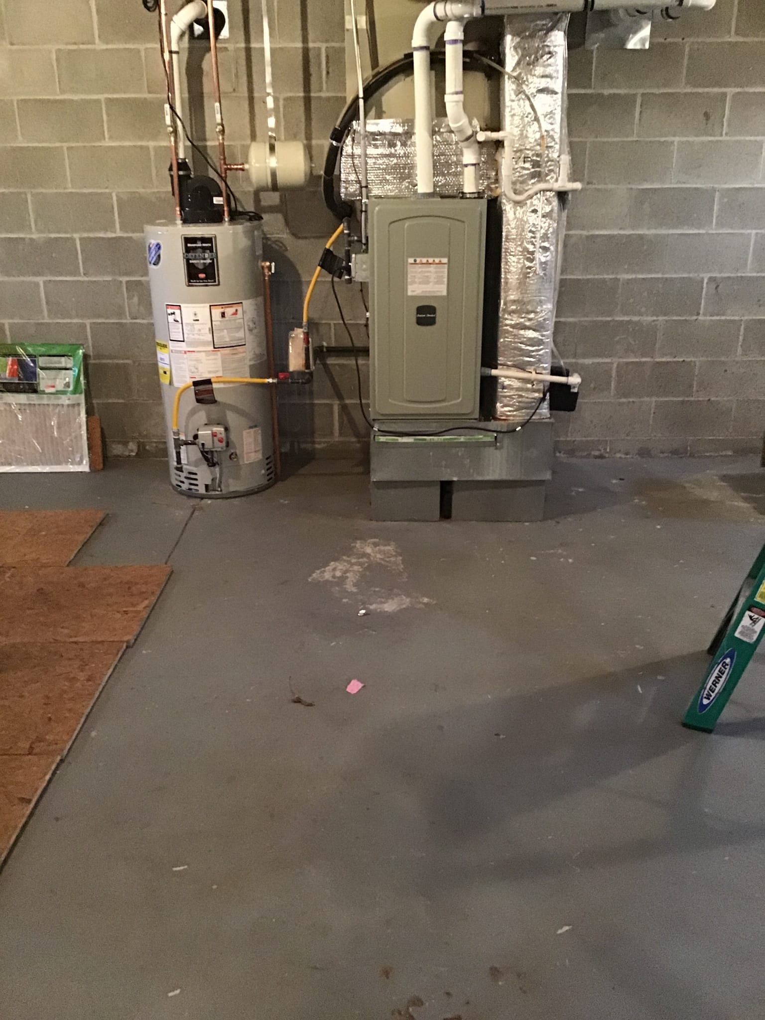 A basement with a water heater and a furnace.