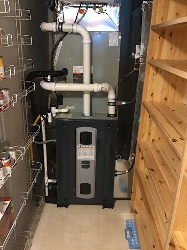 A gas heater is sitting in a pantry next to a wooden shelf.