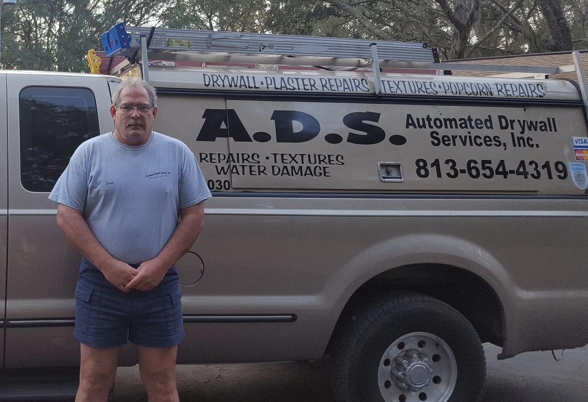 A man standing in front of an a.d.s. truck