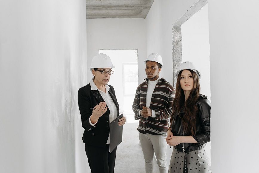 three persons discussing construction