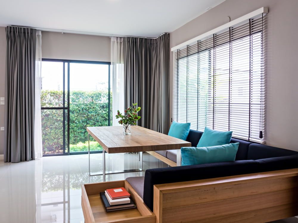 A Living Room With a Couch, Table, and Blinds — Tully Blinds in Tully, QLD