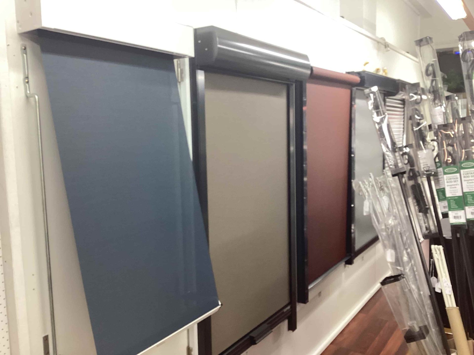 A Row of Roller Blinds Are Lined Up on a Wall in a Store — Tully Blinds in Tully, QLD