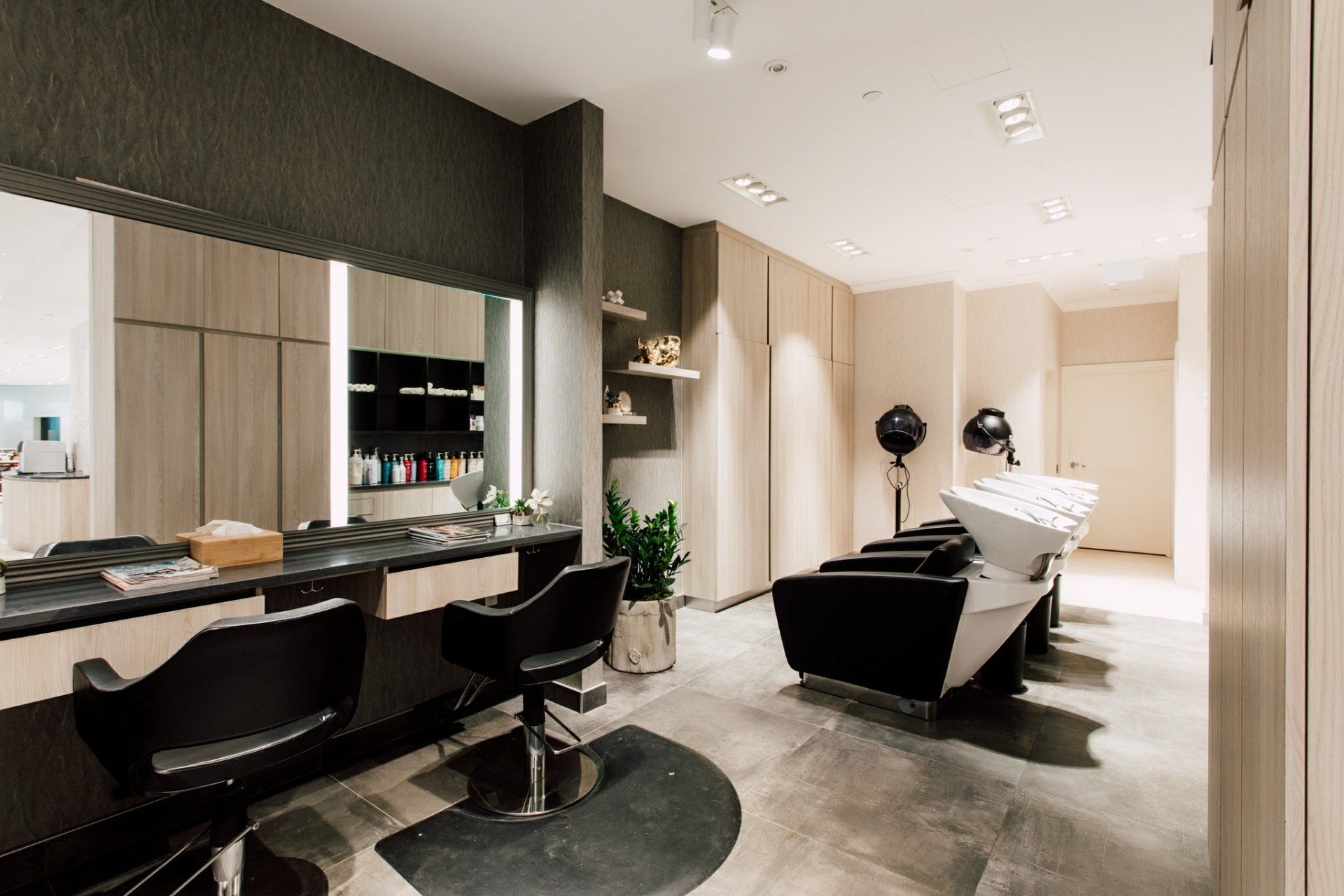 A hair salon with a sink and chairs in it.