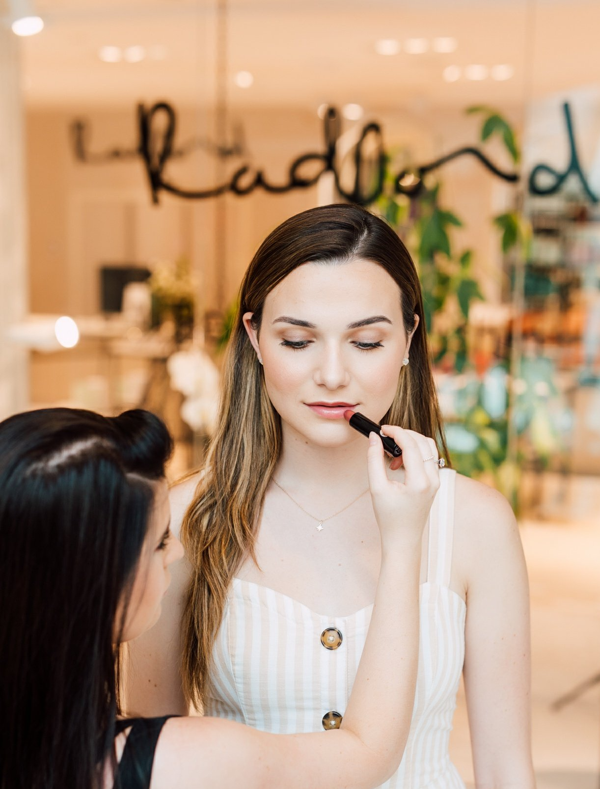 a woman getting her makeup touched up on