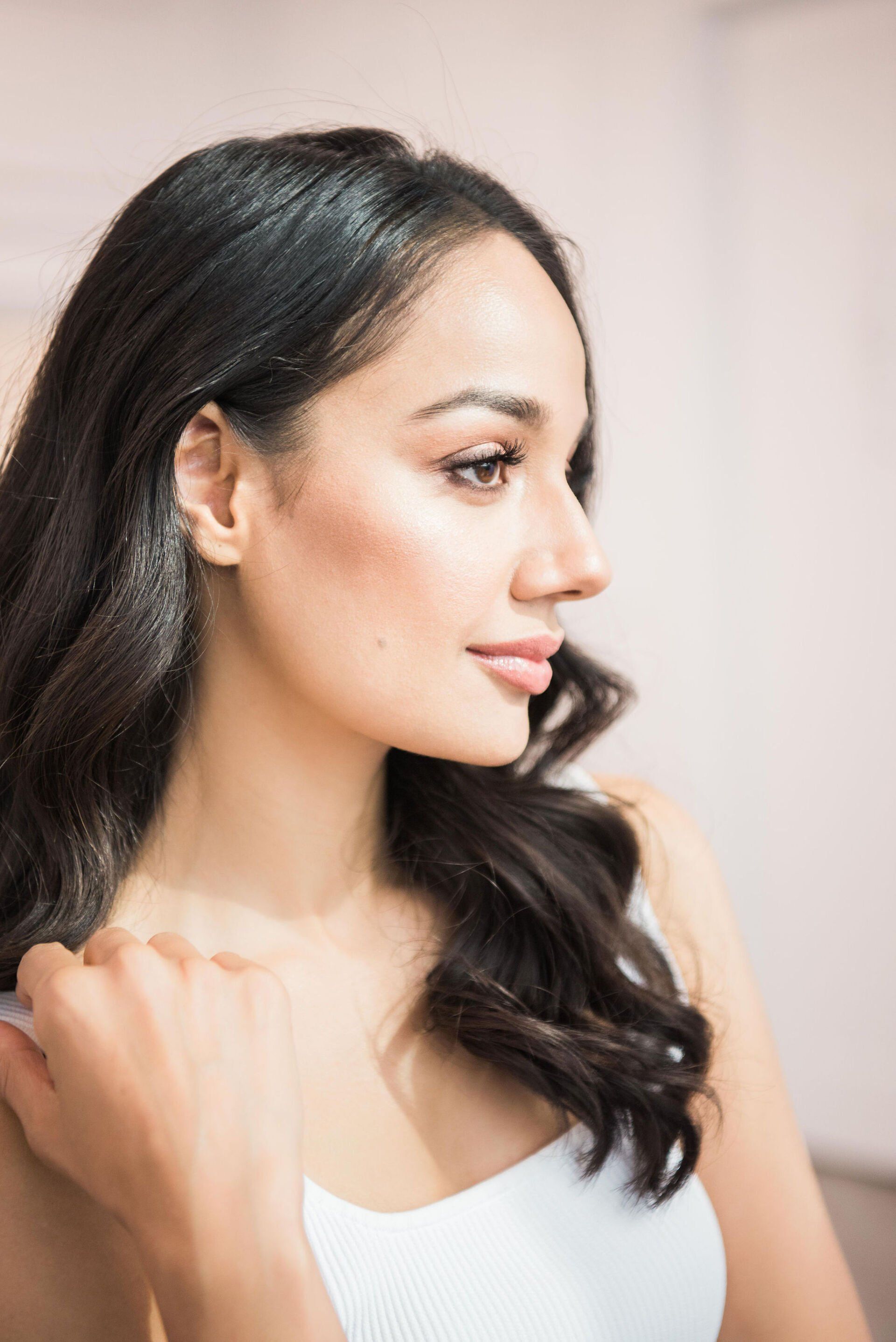 A close up of a woman 's face with her hand on her shoulder.