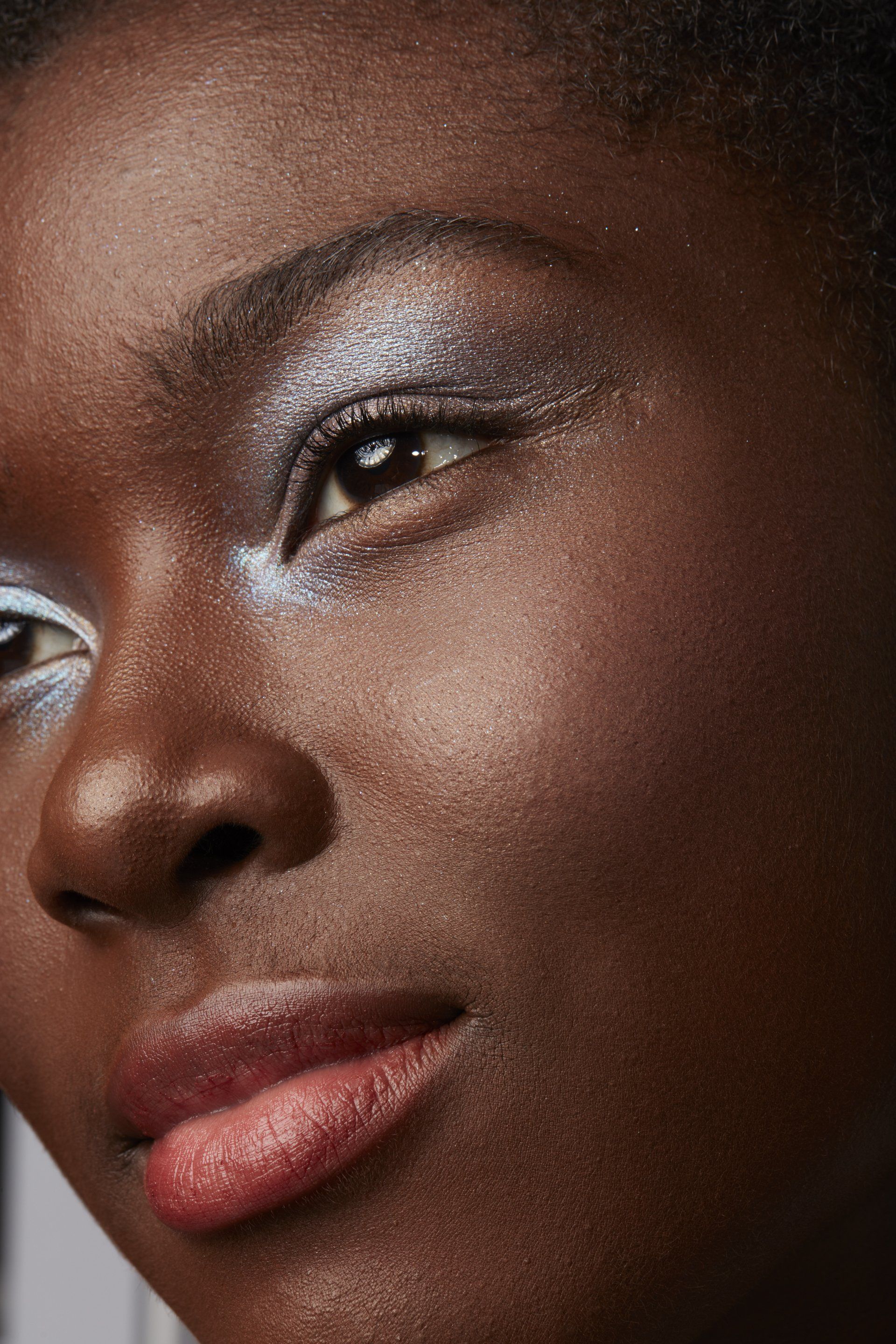 A close up of a woman 's face with silver eye shadow.