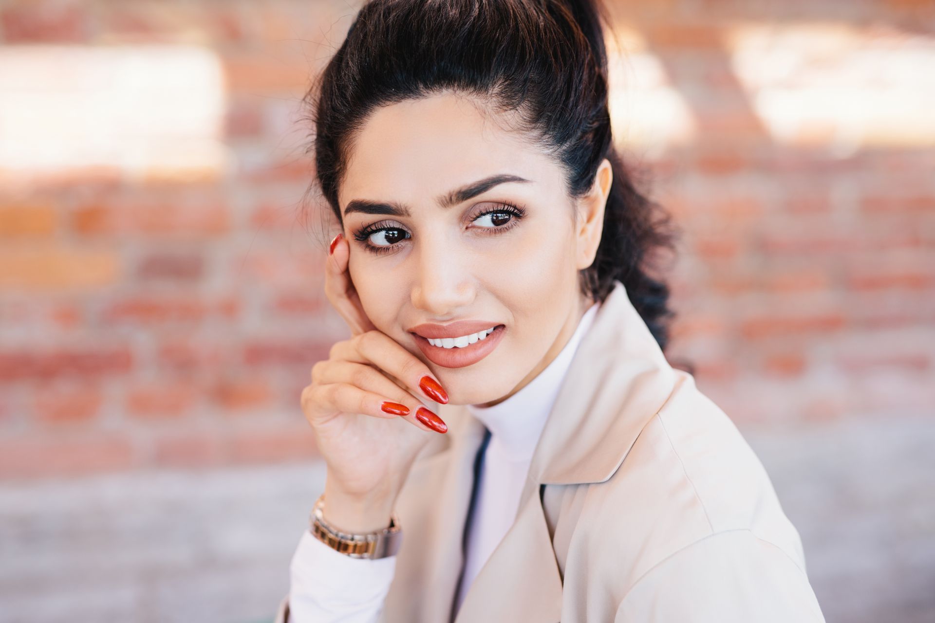 A close up of a woman 's face with her hand on her chin.