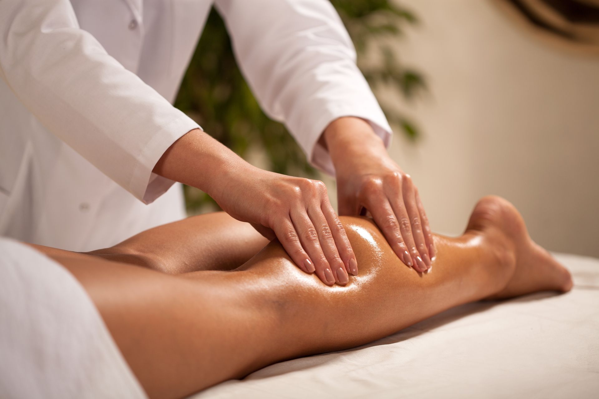 A woman is getting a massage on her leg in a spa.