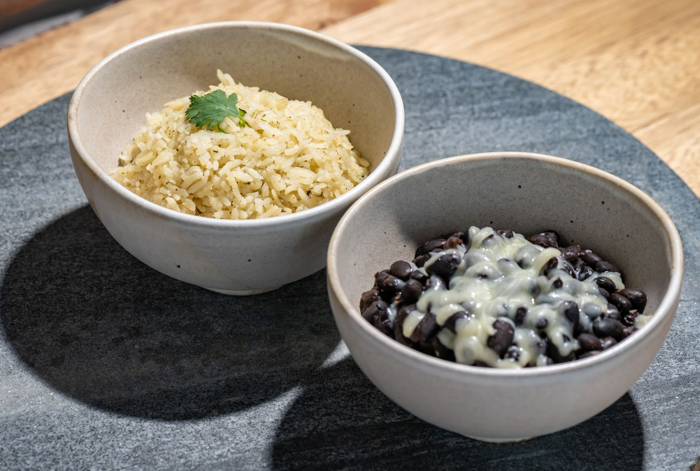 Salad with lettuce, avocado, corn, beans, salsa, and tortilla chips; dipping sauce in a cup.