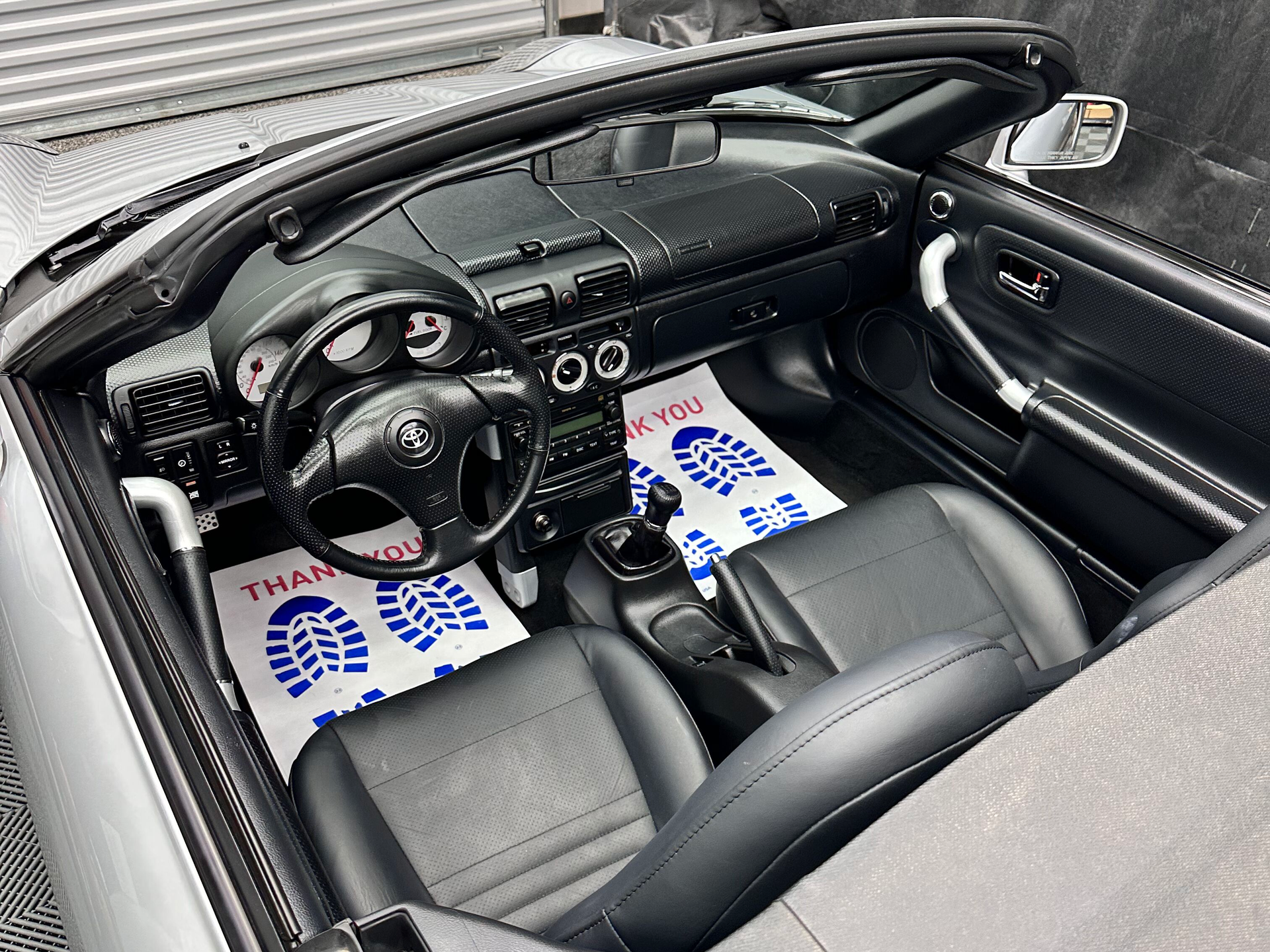 Black interior of a silver Toyota MR2 Spyder convertible.