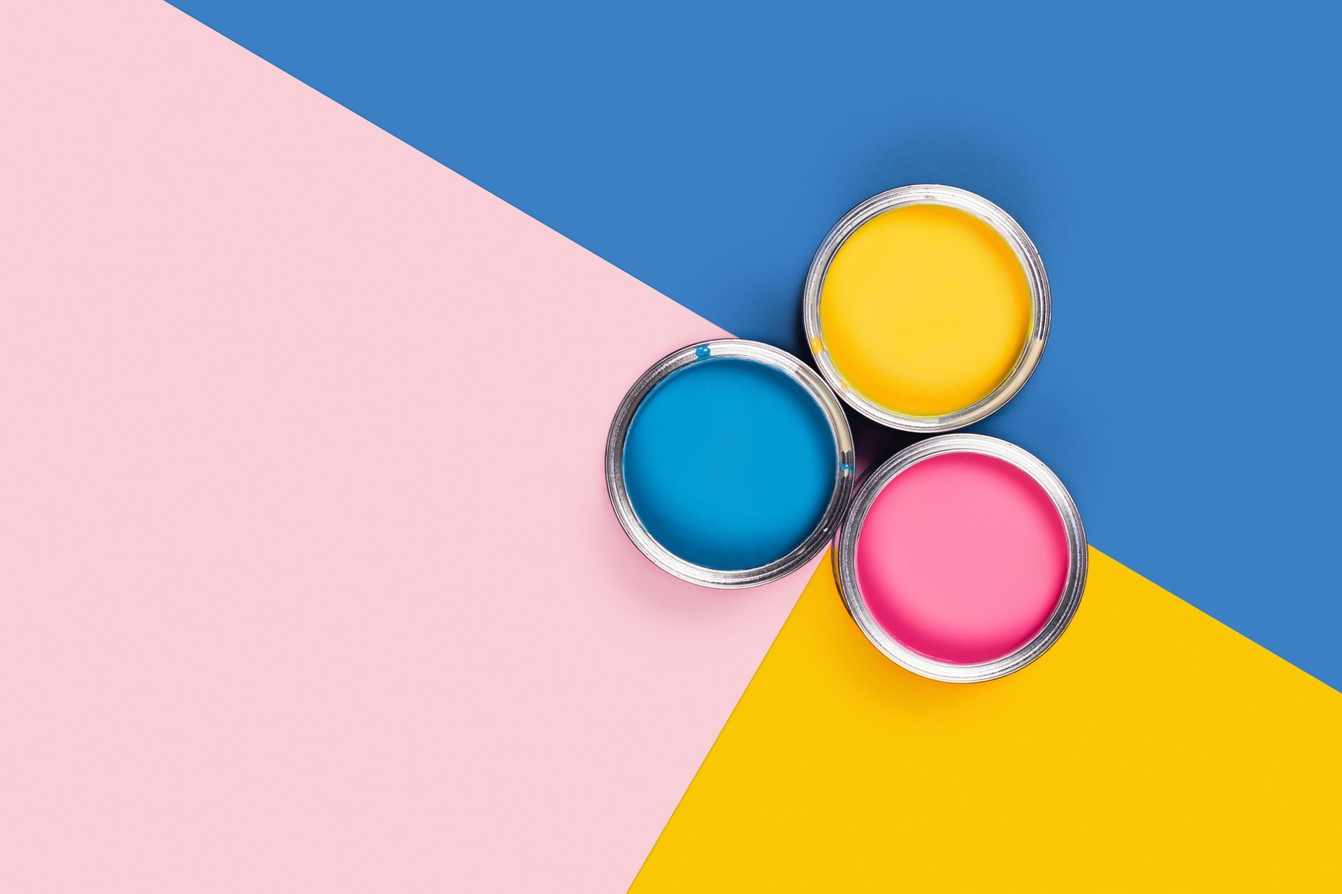 Three open paint cans—yellow, blue, and pink—on vibrant backdrop.