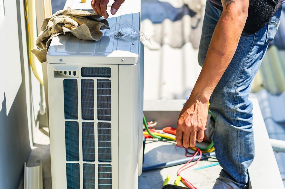 HVAC Technician Working on an Air Conditioning Unit on a Rooftop — Wards Group QLD In Kingaroy, QLD