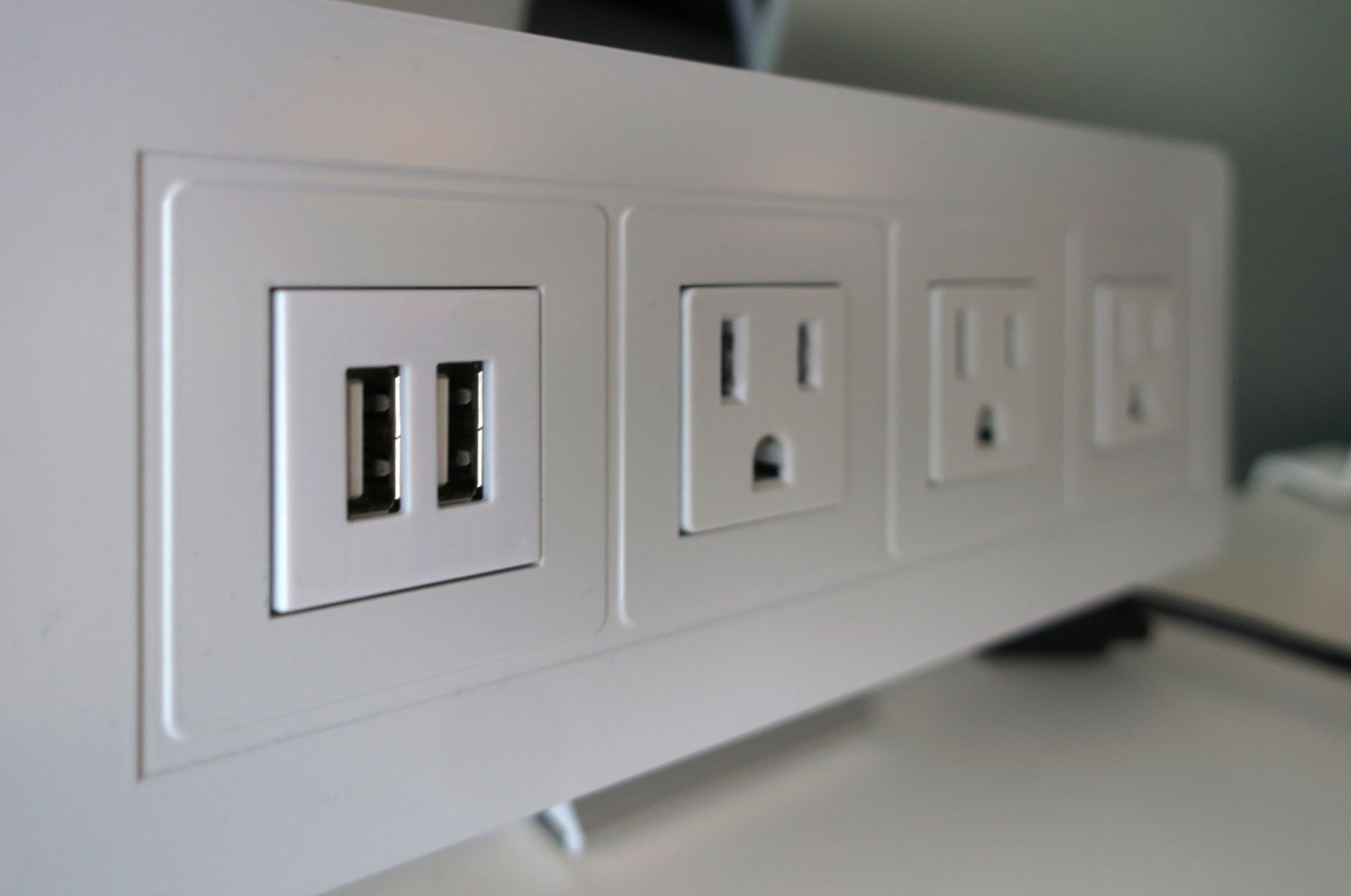 A row of white electrical outlets on a wall