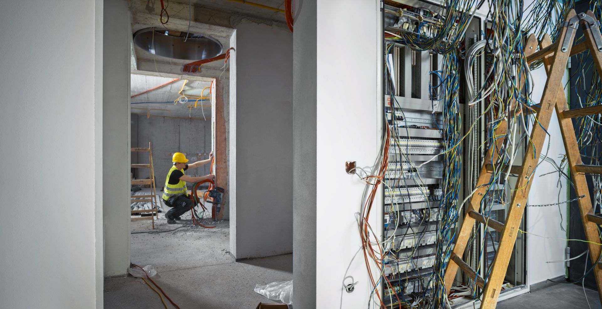A construction worker is working on a wall in a building under construction.