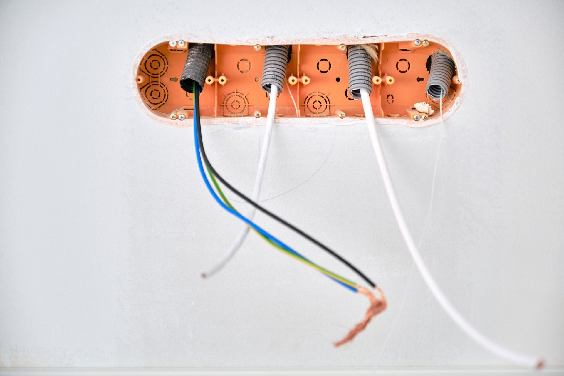 A close up of an electrical box with wires coming out of it.