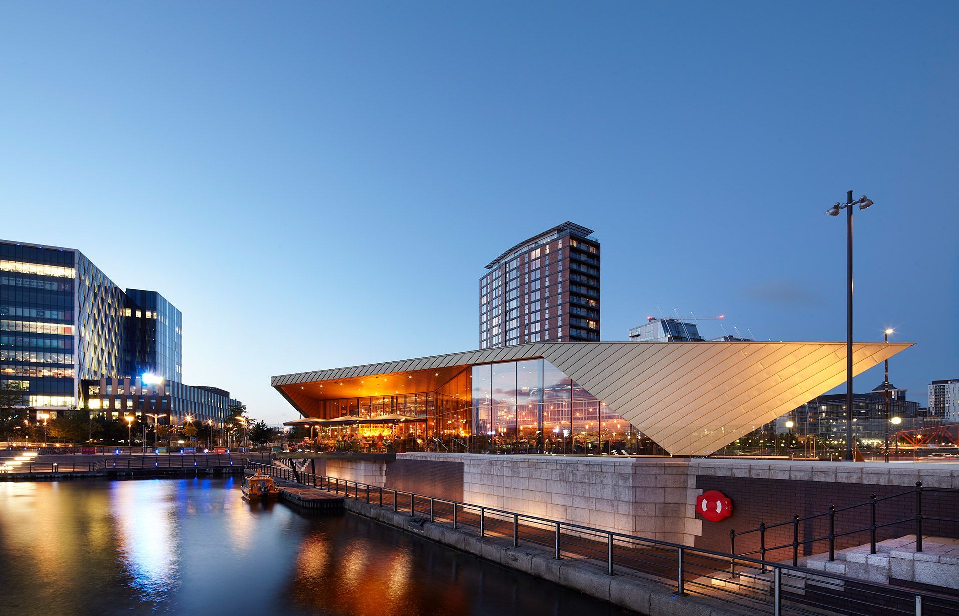 A large building is sitting next to a body of water.