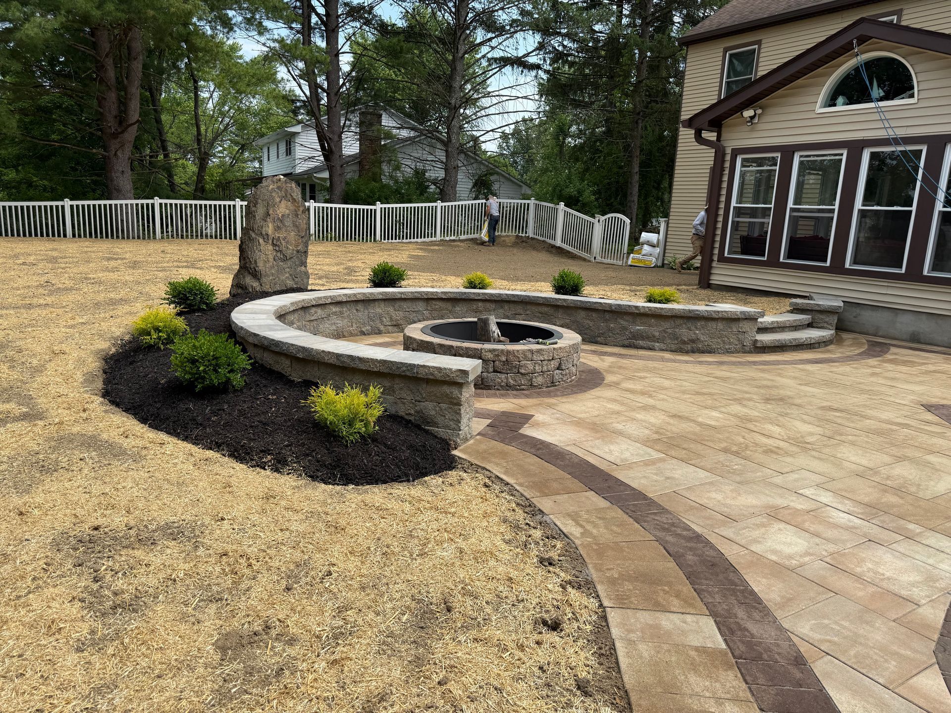 There is a fire pit in the backyard of a house.