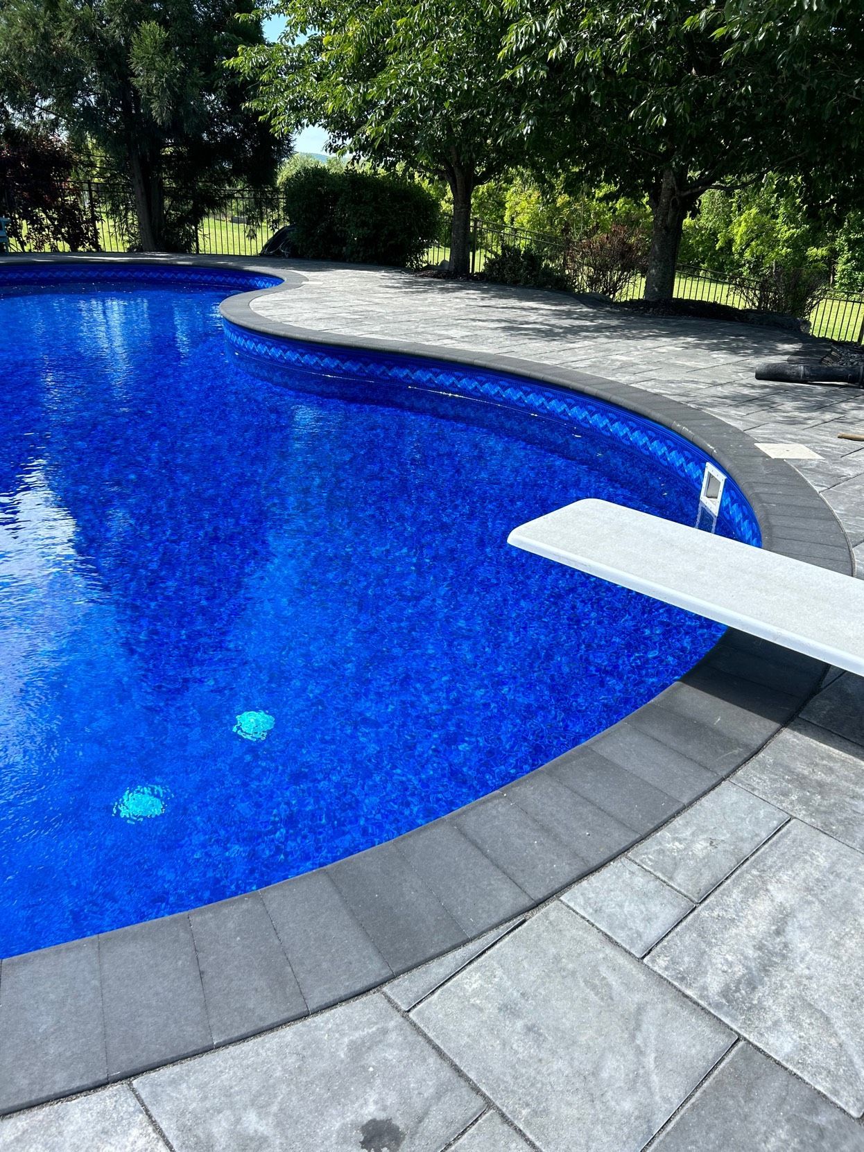 A large swimming pool with a diving board in the middle