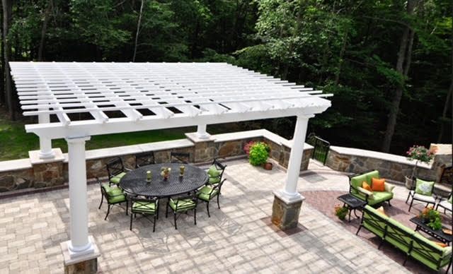 A patio with a table and chairs under a pergola.