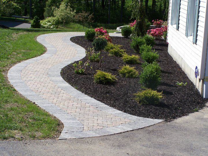 A brick walkway with rocks in the middle of it