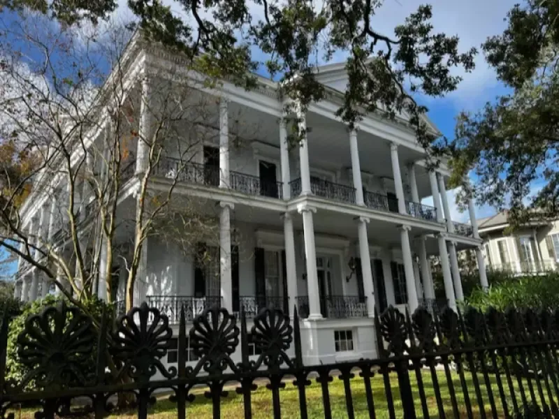 A large white house with a black fence in front of it