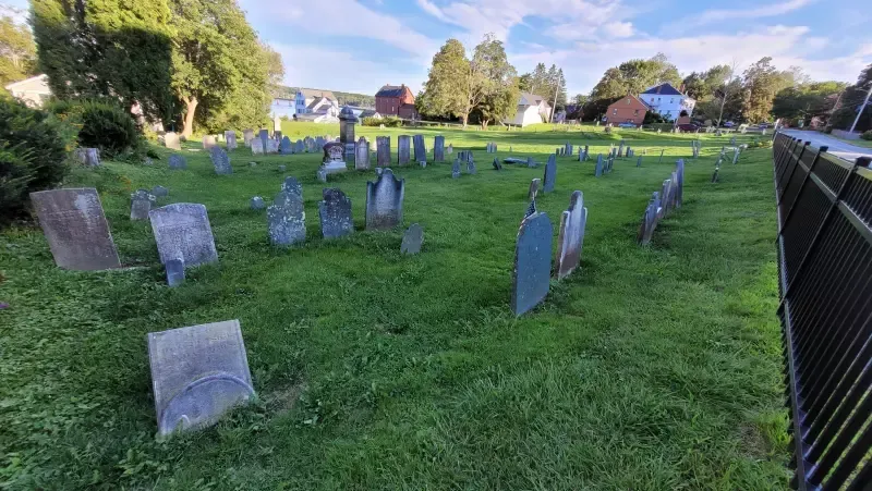 A cemetery with a lot of graves in the grass.