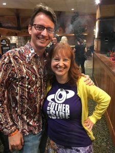 A man and a woman are posing for a picture in a restaurant.