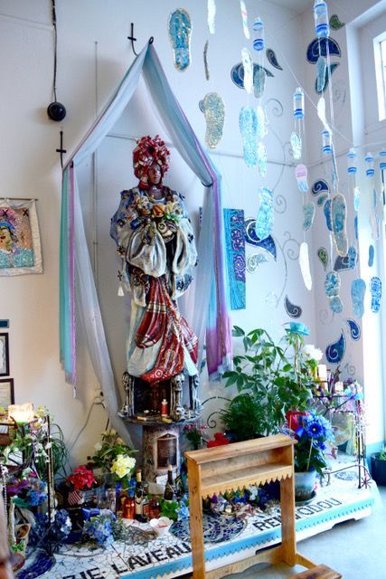 A room with a statue of a woman surrounded by flowers