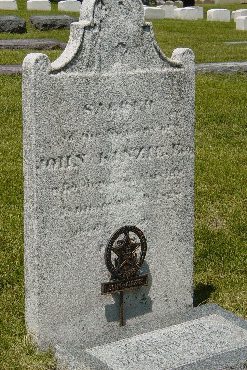 A gravestone in a cemetery with a star on it.