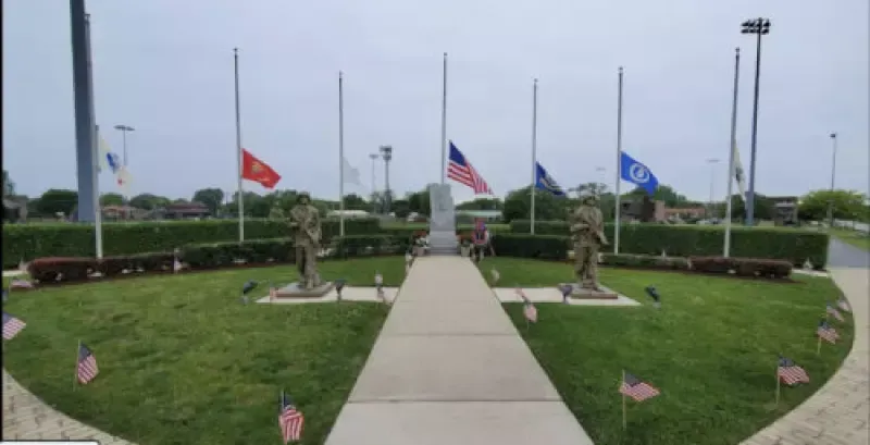 A statue of a soldier is in the middle of a circle of flags.