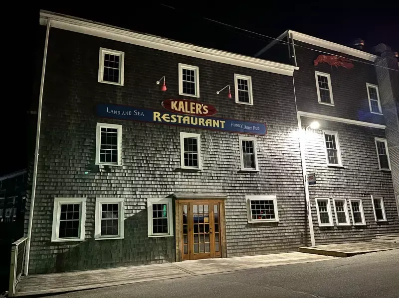 A large building with a sign that says kalek 's restaurant is lit up at night.
