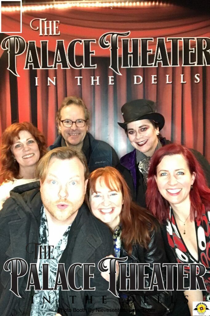 A group of people are posing for a picture at the palace theater in the dells