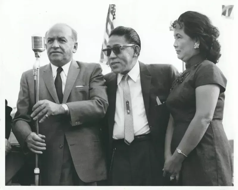 A man in a suit and tie is holding a microphone