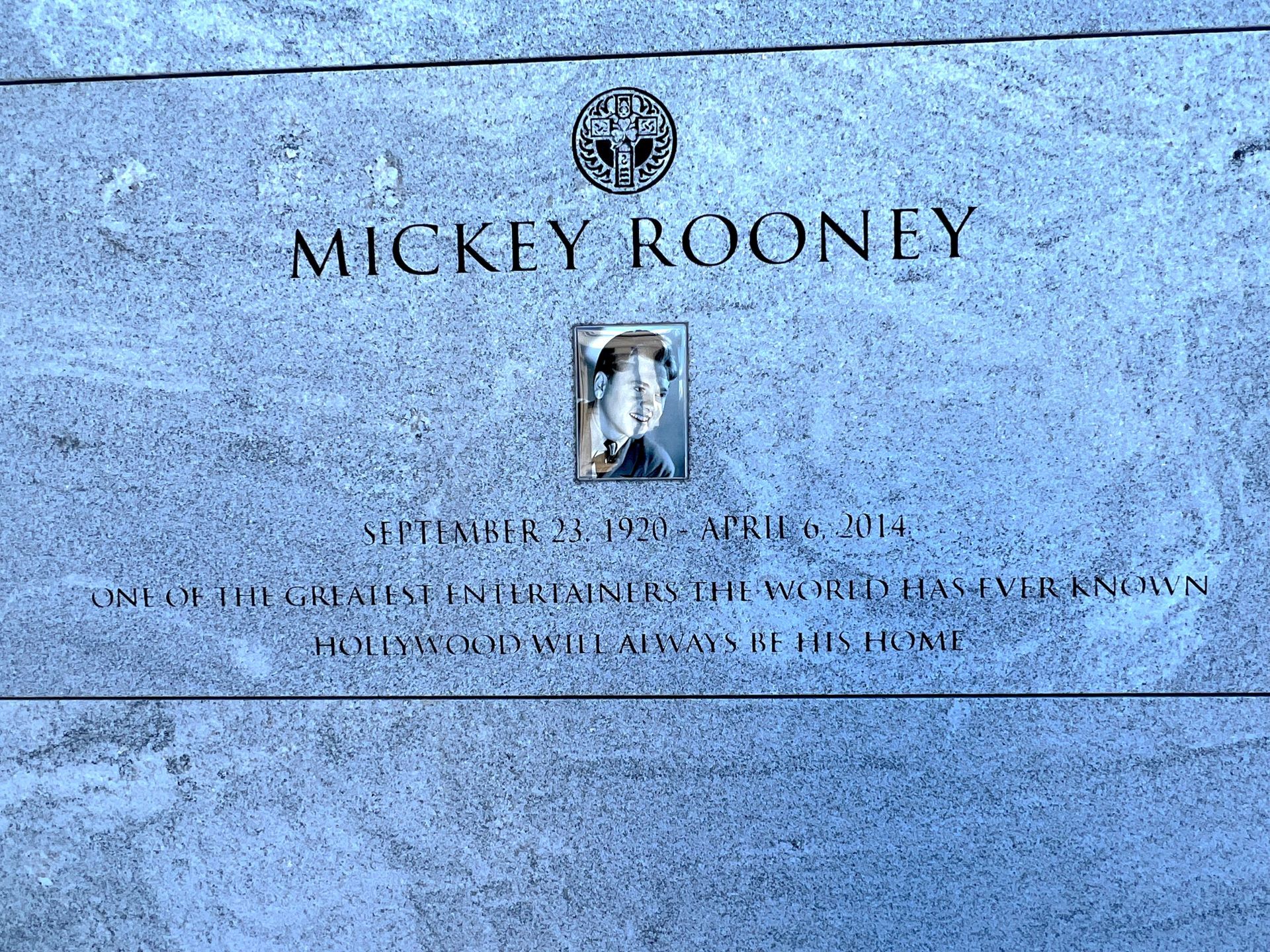 A gravestone for mickey rooney with a picture of him on it