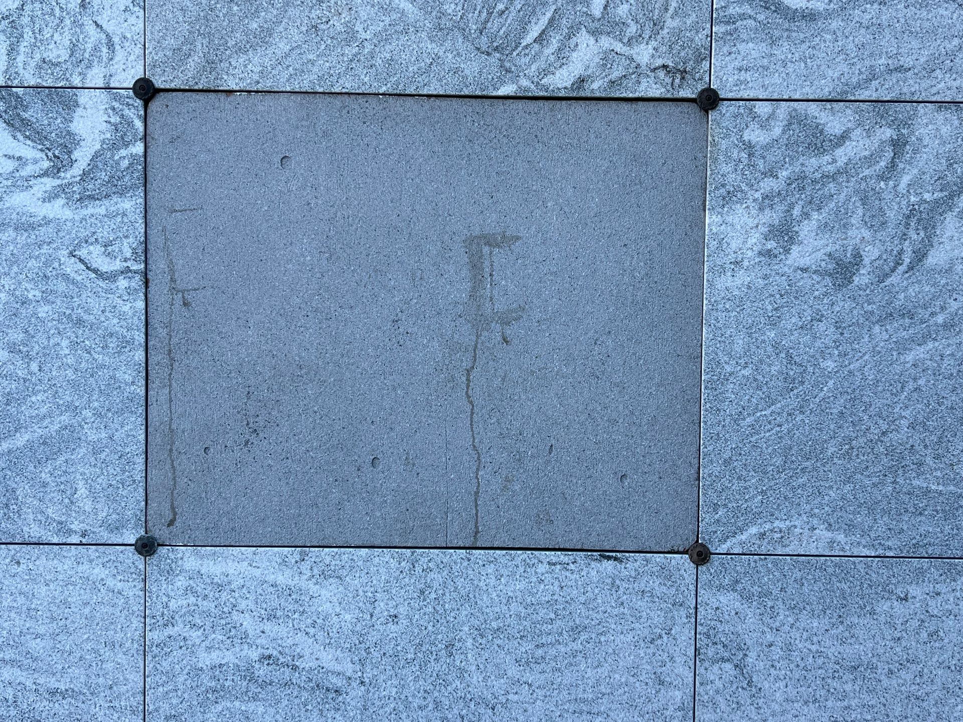 A gray tile floor with a square in the middle