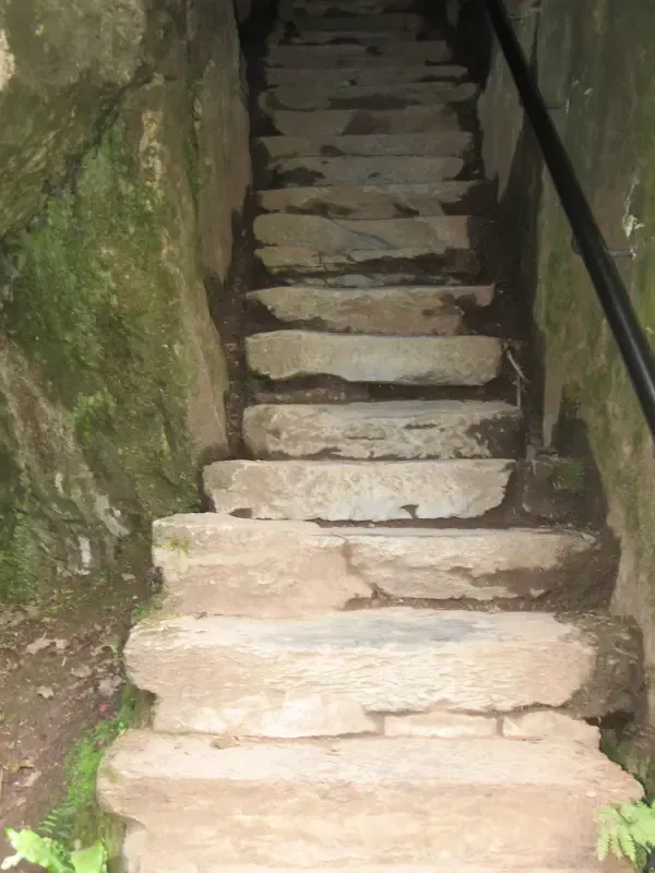 A set of stone stairs leading up to a cave.