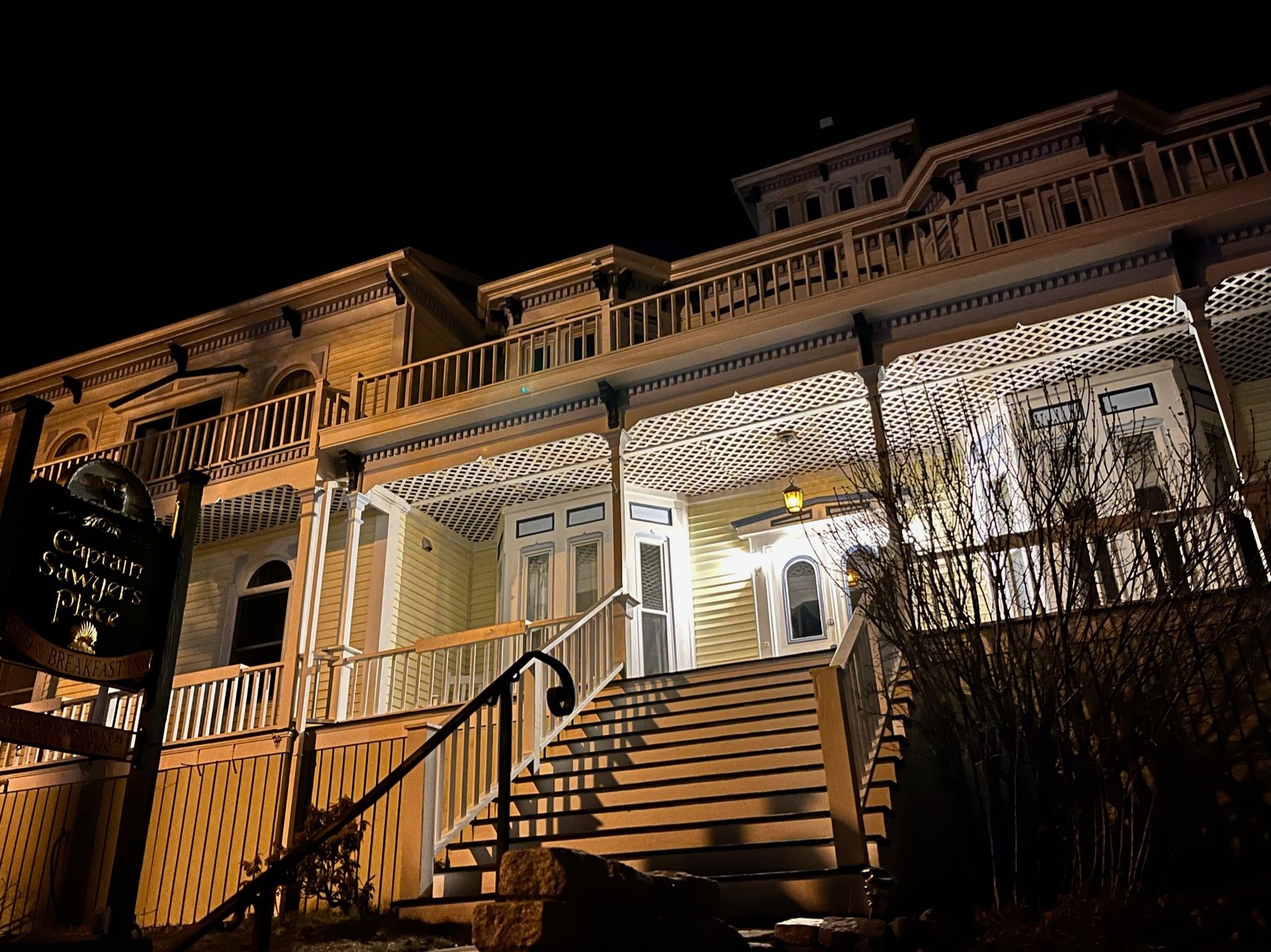 A large house with stairs leading up to it at night